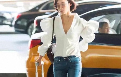 袁姗姗身穿白色泡泡袖衬衫搭配浅色牛仔裤，瞬间年轻了不少